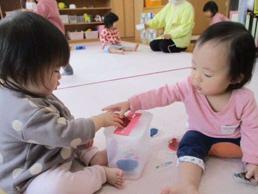 0歳児がプラバン落としをしている
